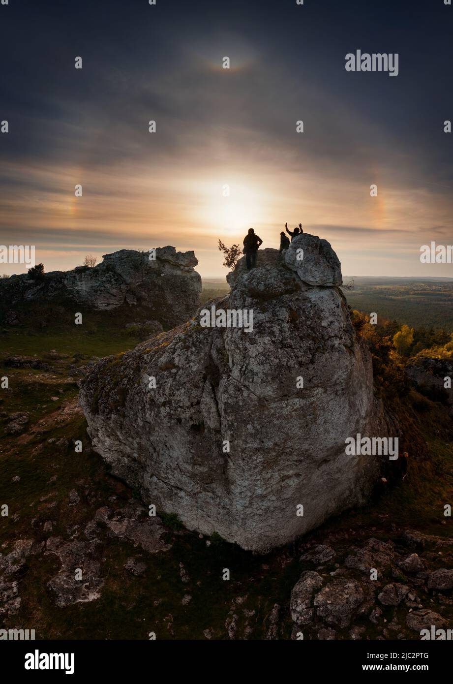 Personnes en formation rocheuse dans le Jura Krakowsko-Czestochowska regardant l'effet halo-soleil, Pologne Banque D'Images