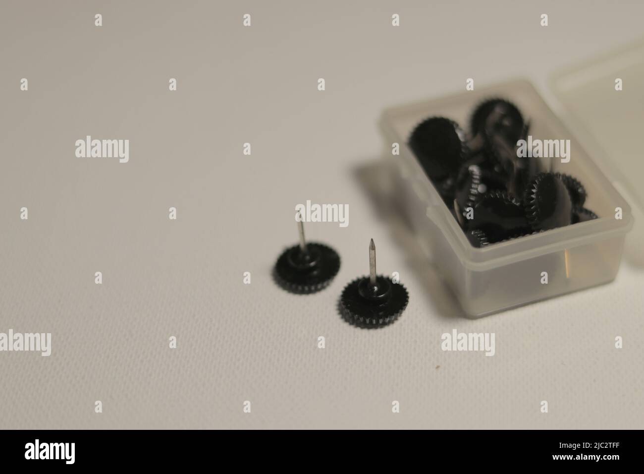 Punaises noires ou broches de carte éparpillées sur fond blanc Banque D'Images