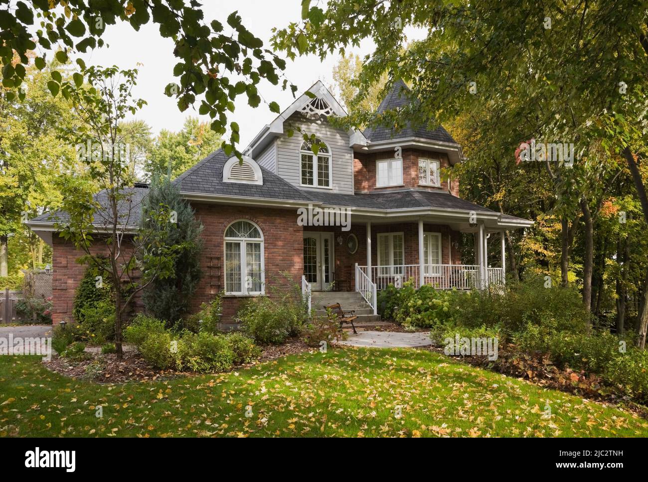 Maison de deux étages en brique rouge avec bordure blanche style cottage victorien en automne. Banque D'Images
