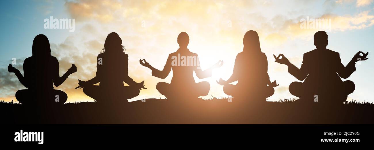 Silhouette de personnes faisant du yoga contre le ciel au petit matin Banque D'Images