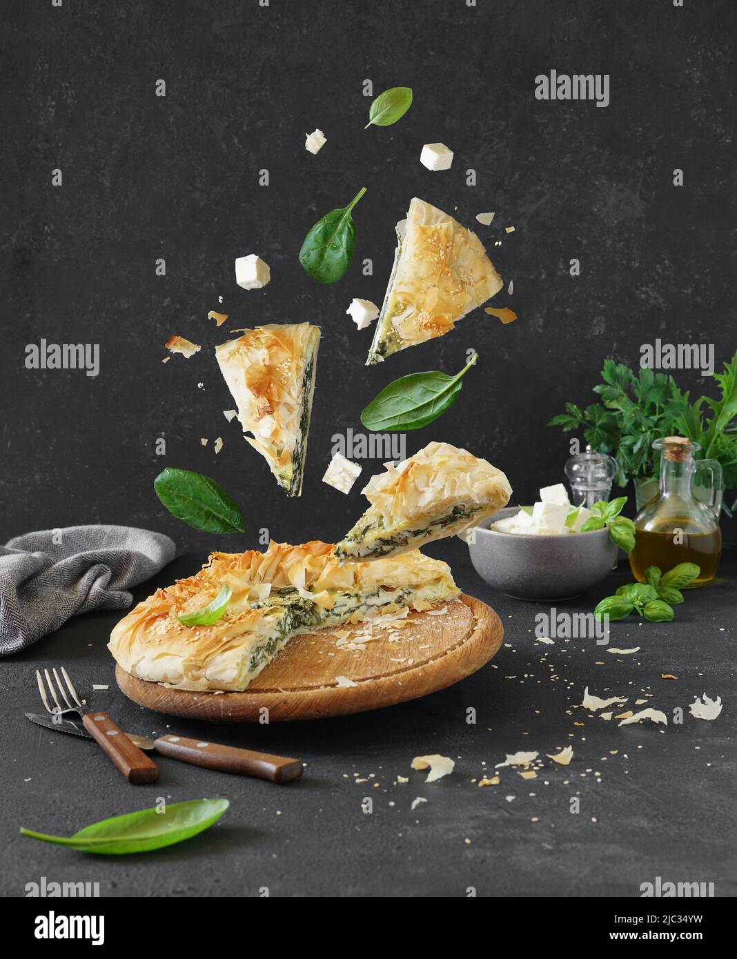 Cuisine grecque traditionnelle. Tarte espagnole et morceaux d'épinards et de fromage feta sur fond sombre Banque D'Images