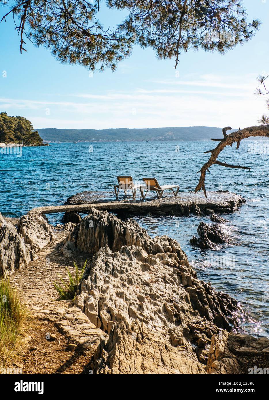 Plage de Kupalište Bene avec chaises longues sur la rive rocheuse du parc forestier de Marjan dans la ville de Split, Croatie Banque D'Images