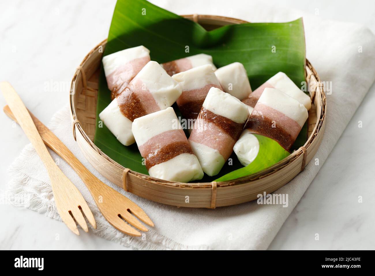 Getuk Tigna Warna ou Getuk Trio, en-cas javanais traditionnel sucré de Magelang. Un mélange de manioc et de noix de coco, servi sur une assiette de bambou sur le blanc Banque D'Images