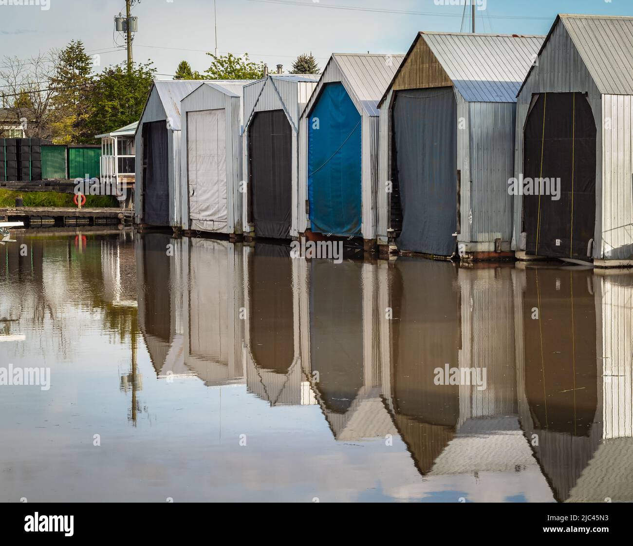 Des maisons de bateau colorées sur une rivière. Tôt le matin lumière du soleil sur le chantier naval, marina. Garages de bateaux flottants sur une eau. Photo de rue, personne, foc sélectif Banque D'Images