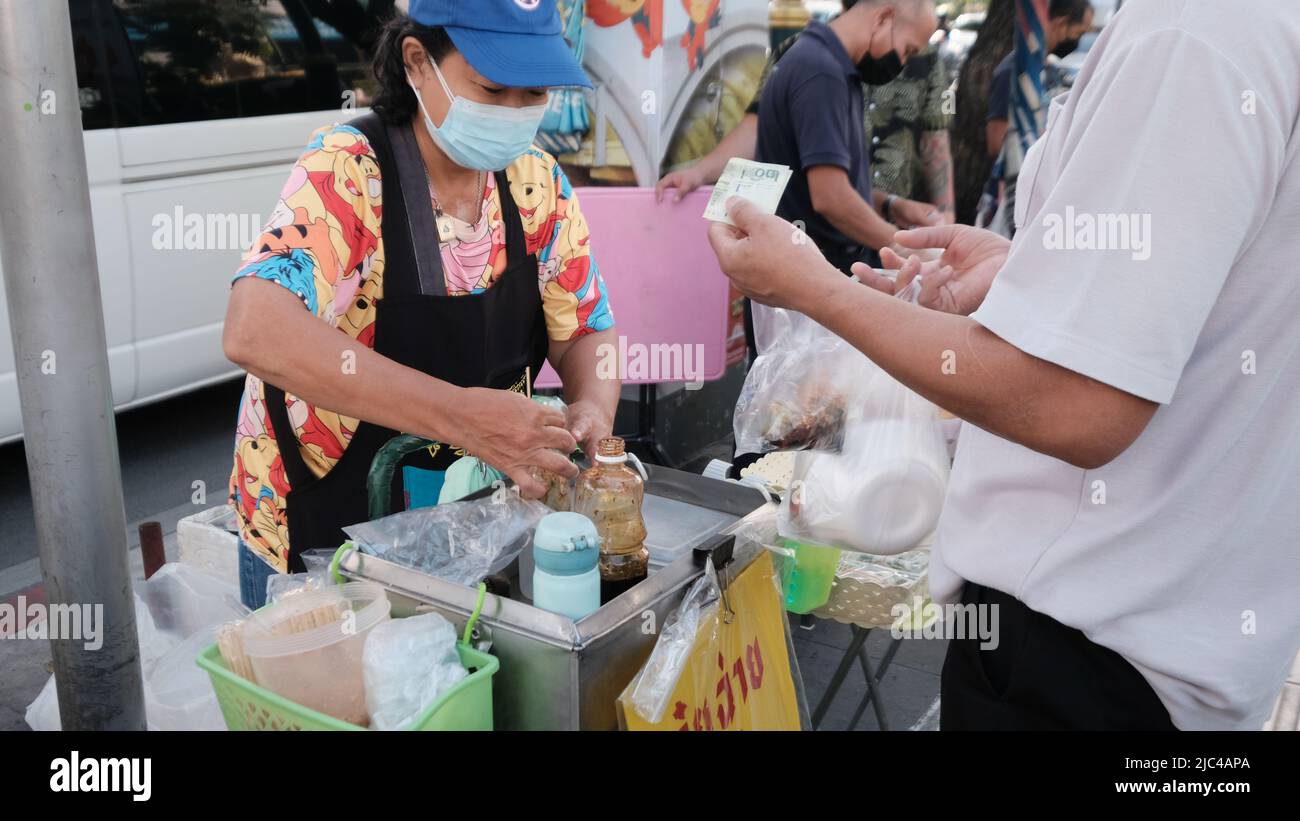 Argent changer les mains Cash transaction Sukhumvit Road Bangkok Thaïlande Banque D'Images