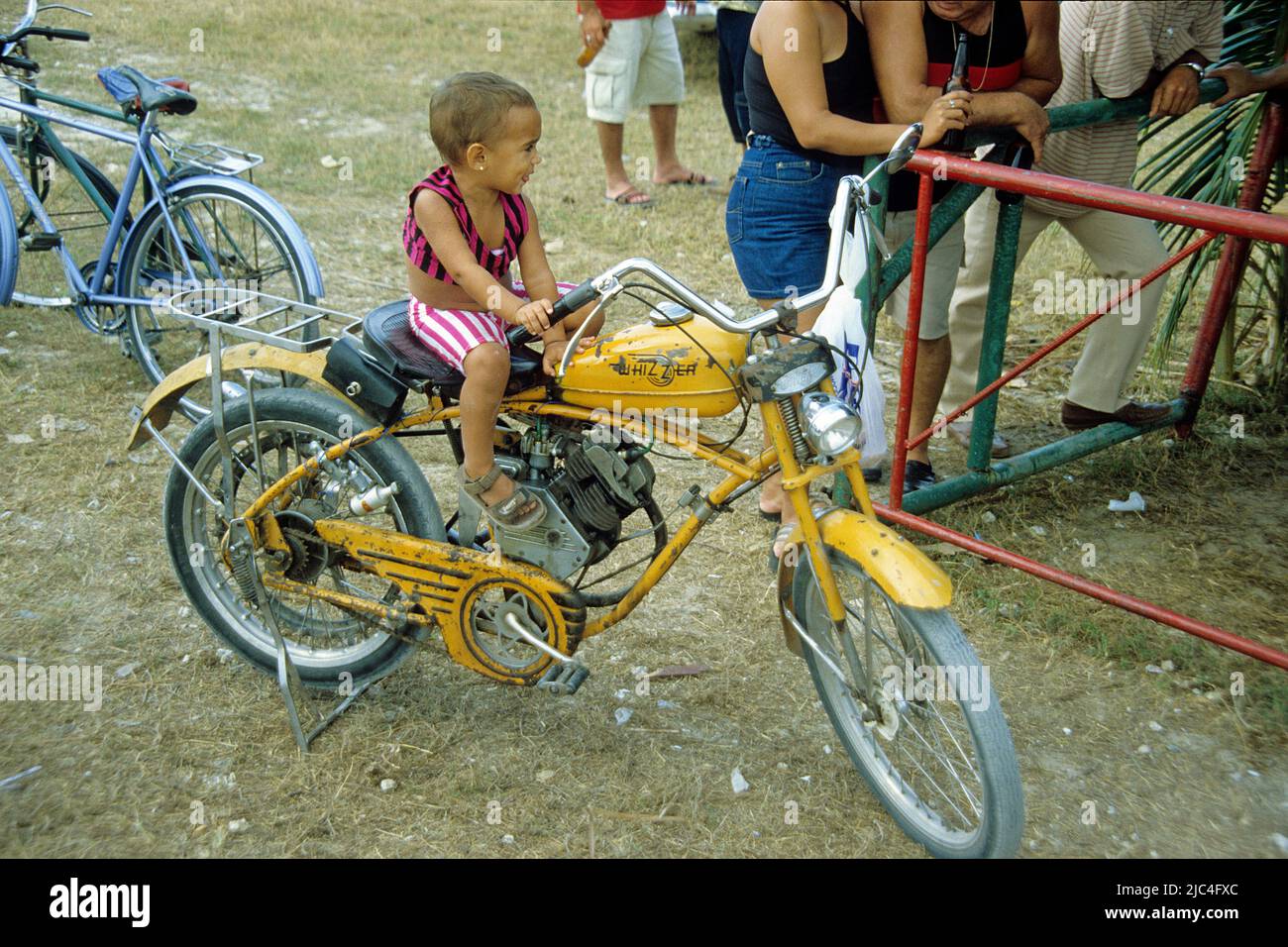 Petit garçon cubain assis sur un vieux Whizzer moto, Fiesta, fête, Sainte-Lucie, Cuba, Caraïbes Banque D'Images