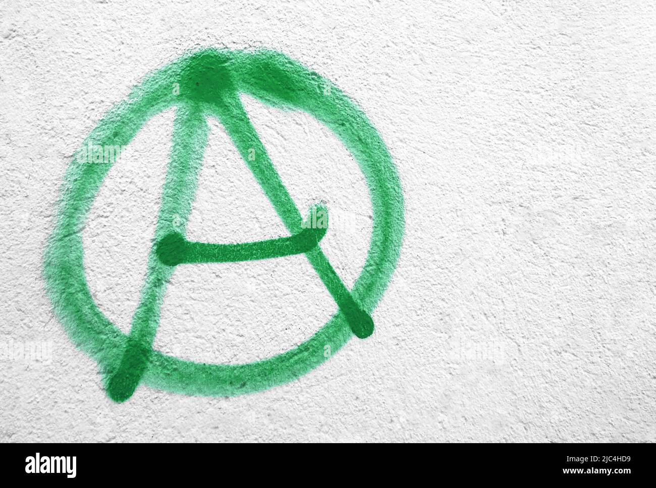 Symbole anarchie vert sur le mur. Idéal pour les textures, les arrière-plans et les concepts. Copier l'espace. Banque D'Images