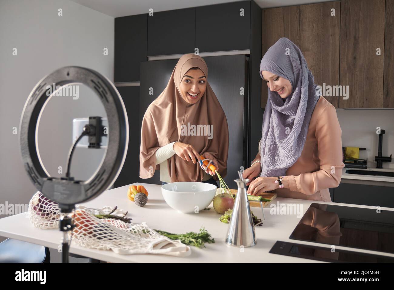 Deux bûcherons musulmans de nourriture explantant comment préparer une salade à la cuisine. Banque D'Images