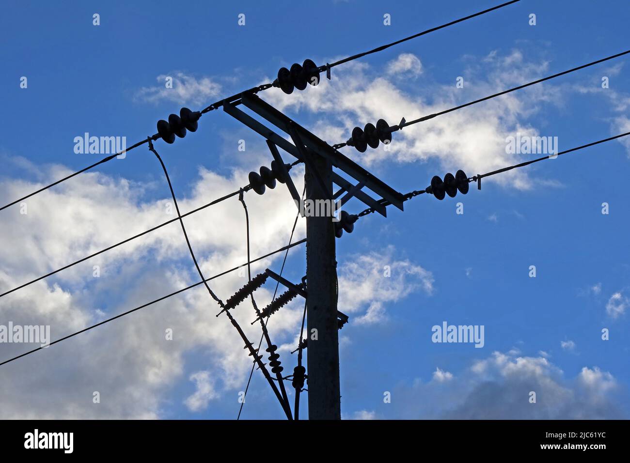 Distribution de lignes électriques triphasées en milieu rural, avec des isolateurs contre un ciel bleu nuageux, Cheshire, Angleterre, Royaume-Uni, WA4 Banque D'Images