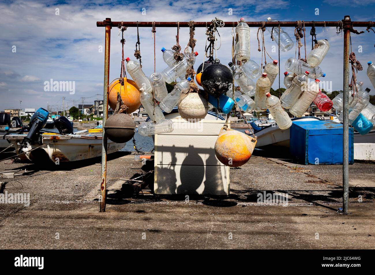 Bouées suspendues au soleil, sur une crémaillère dans le petit village de pêcheurs d'Arisaki, près de Yokosuka, au Japon. Banque D'Images