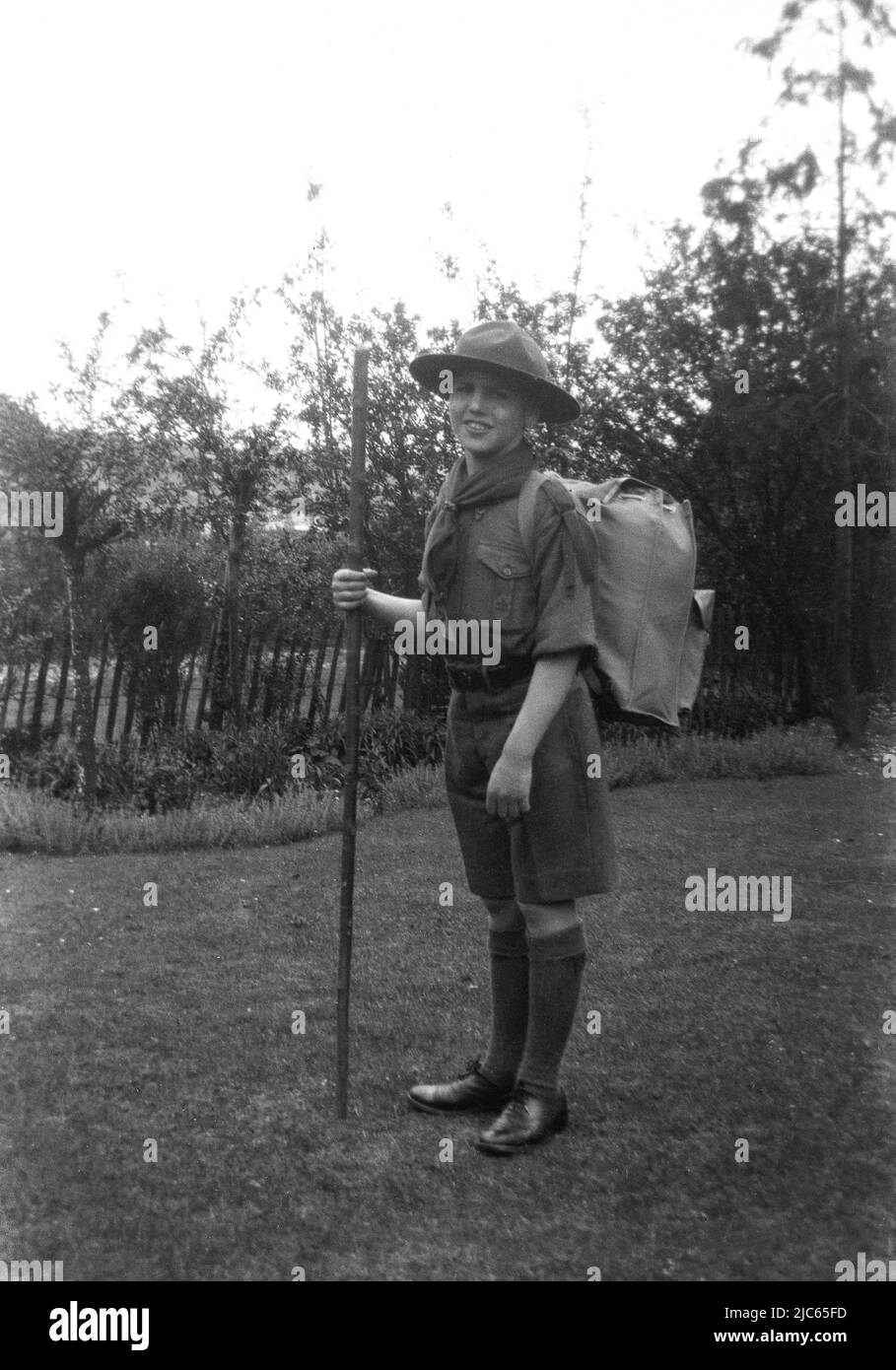 1934, historique, scout de garçon en uniforme et avec sac de kit sur son dos prêt pour le camp de scout à Bossington, Angleterre, Royaume-Uni. Banque D'Images