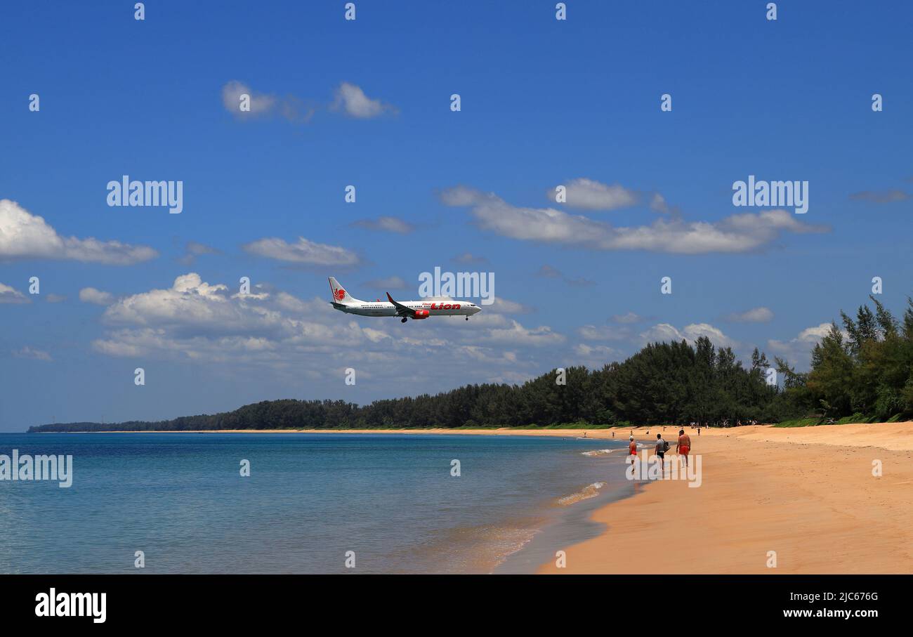 Avion de ligne ou avion de passagers THAI LION AIR Boing 737-900ER atterrissage à l'aéroport à côté de la plage. L'avion vole extrêmement bas au-dessus de la plage de mer. Banque D'Images