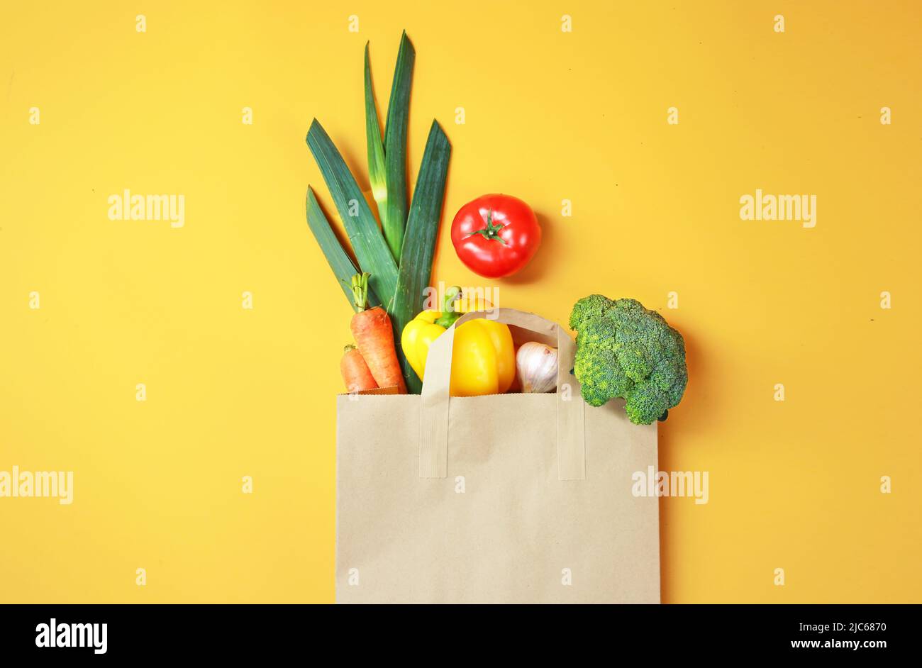 Légumes dans le sac de papier sur fond jaune.épicerie.marché en ligne.alimentation de supermarché. Banque D'Images