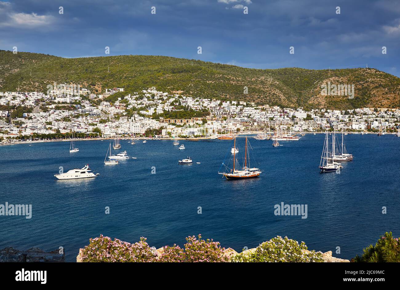 Vue sur la plage de Bodrum depuis le château. Bateaux à voile, yachts à la mer Égée avec maisons blanches traditionnelles sur les collines de la ville de Bodrum en Turquie Banque D'Images