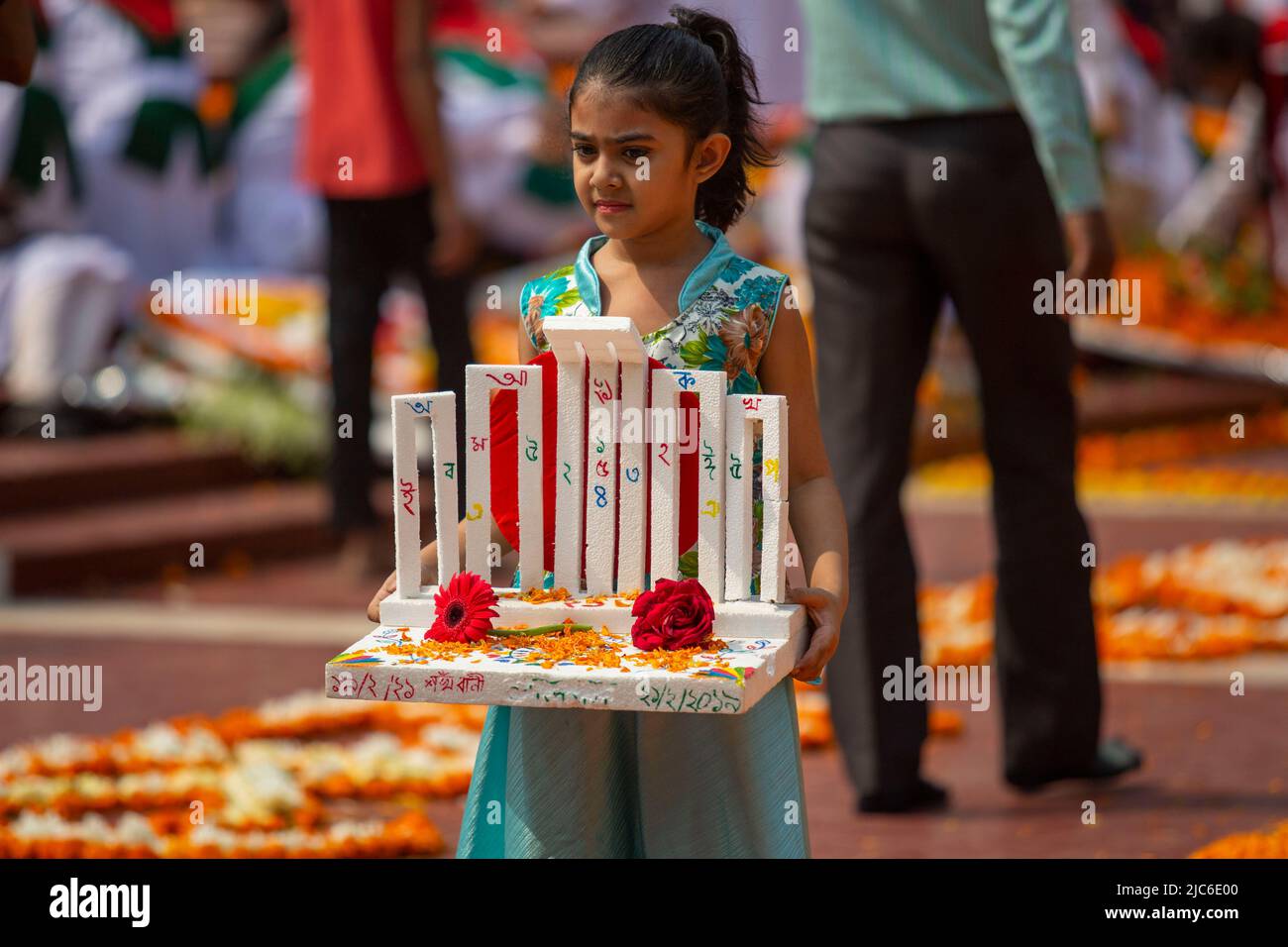 Une fille détient une réplique du Minar central de Shaheed à l'occasion de la Journée internationale de la langue maternelle, à Dhaka, au Bangladesh. Banque D'Images