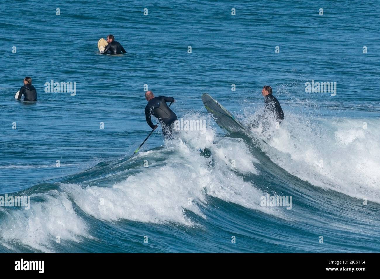 Un Paddleboarder debout en collision avec un surfeur à Fistral à Newquay en Cornouailles. Banque D'Images