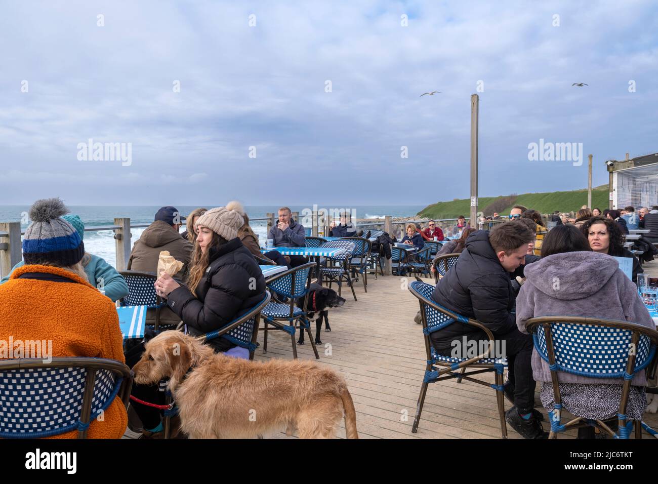 Les personnes qui apprécient un café et un en-cas sur la terrasse du Fistral Beach Bar à Fistral à Newquay, en Cornouailles, au Royaume-Uni. Banque D'Images