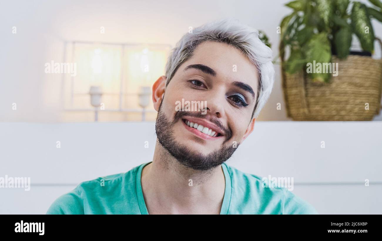 Happy gay sexe liquide homme regardant la caméra intérieur à la maison - homme transgenre portant le maquillage - concept de diversité LGBTQ Banque D'Images