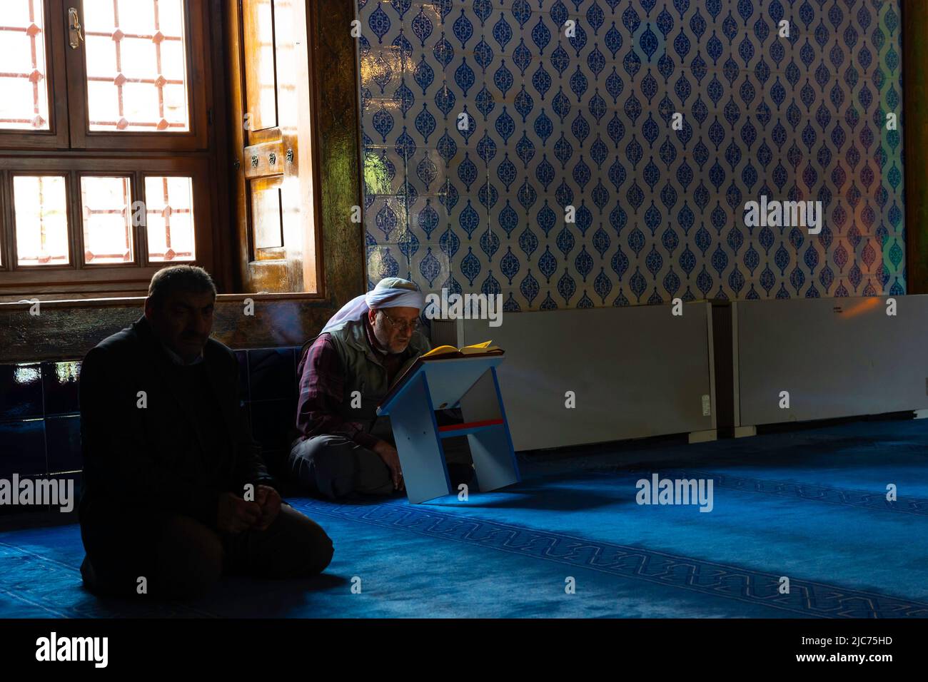 Photo de fond islamique. Un homme musulman aîné lisant quran dans la mosquée près de la fenêtre. Ramadan ou islam ou kandil ou laylat al-qadr ou kadir geces Banque D'Images