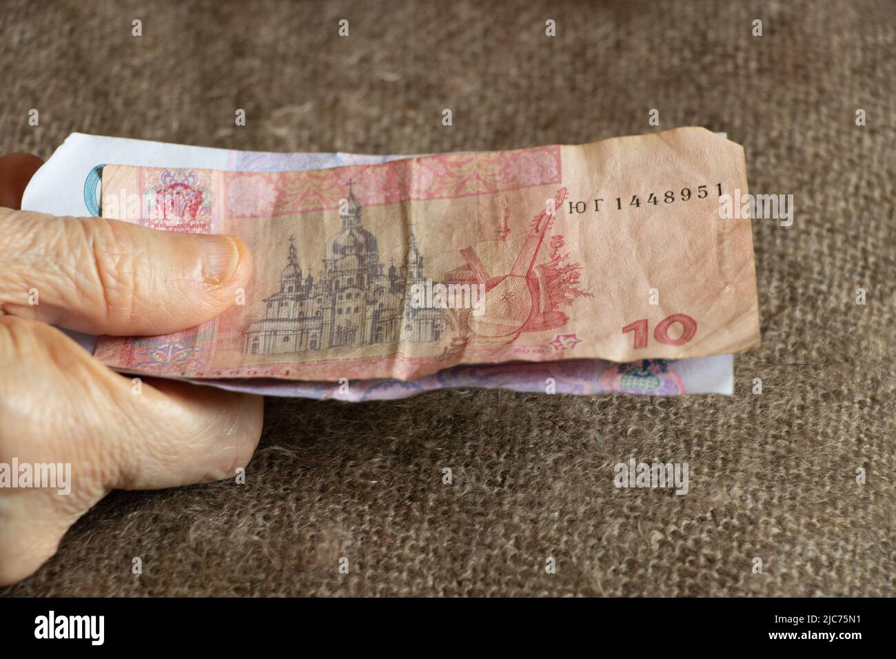 Ukrainien dix et cinquante hryvnias entre les mains d'une vieille femme, de l'argent entre ses mains Banque D'Images