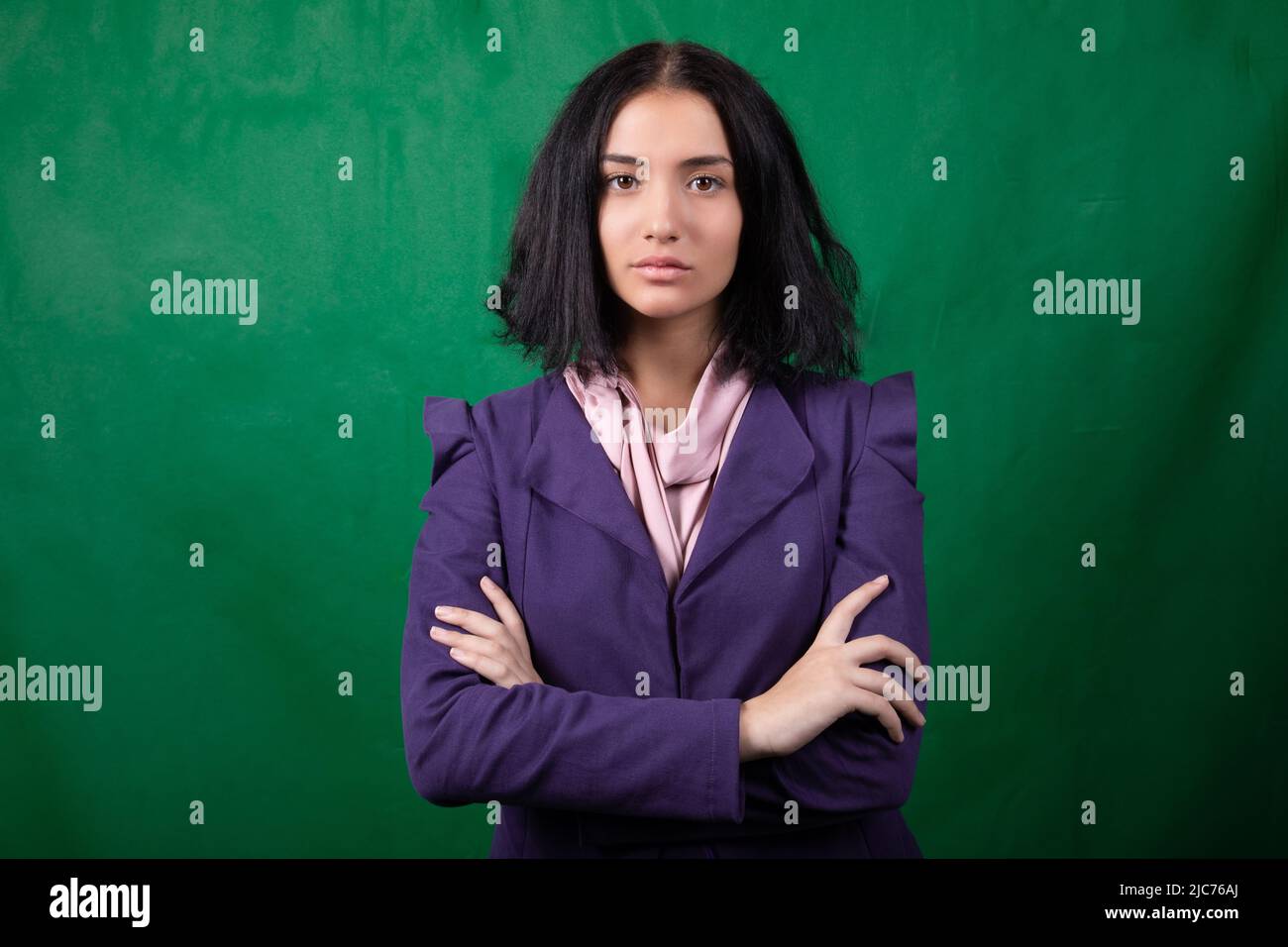 Jeune joli modèle posant avec des coudes croisés dans le portrait de studio Banque D'Images