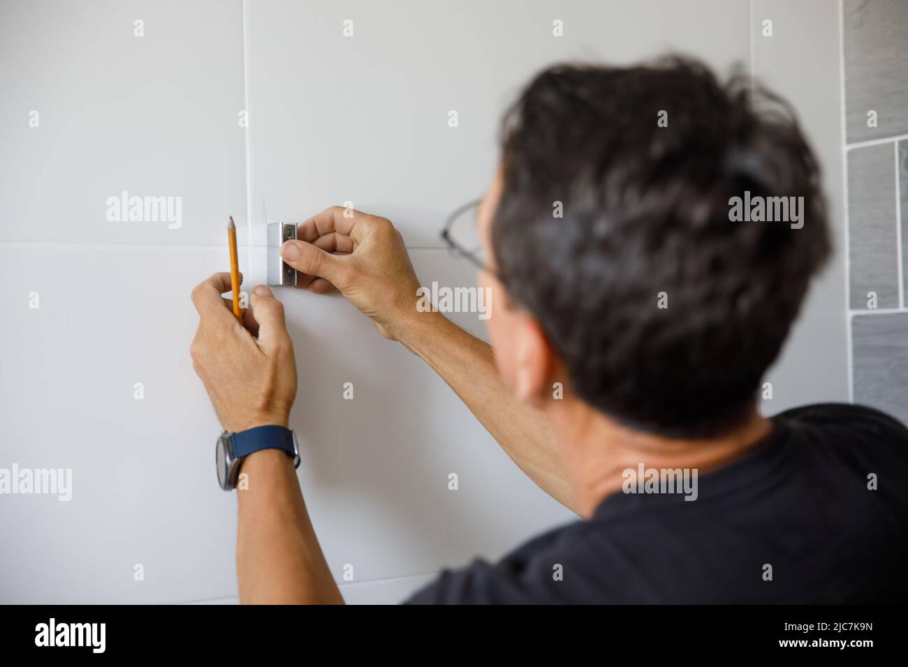 Un homme fait des réparations dans la salle de bains. Banque D'Images