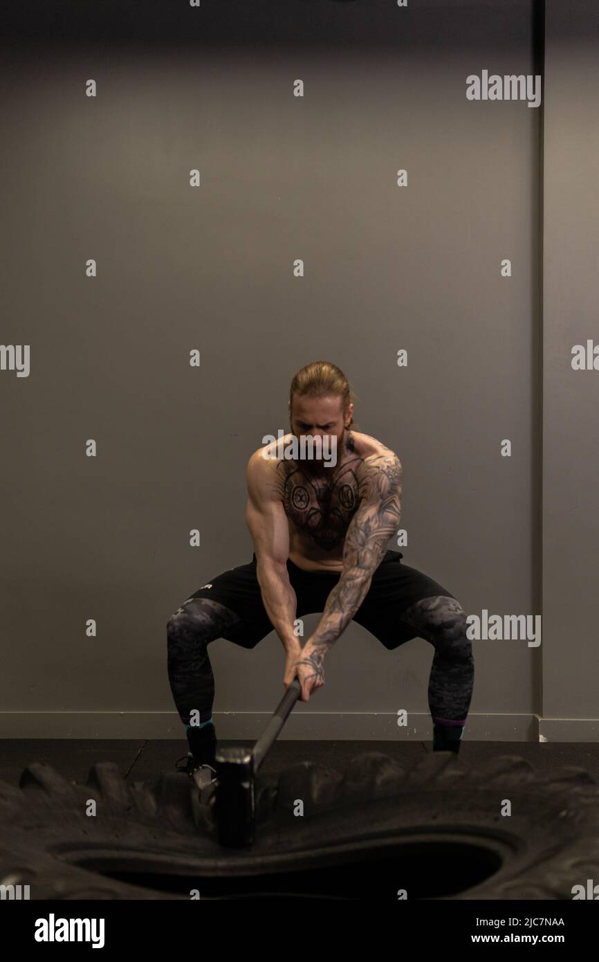 Sledgehammer camion roue roue pneu femme remplacer jeune Hammer gym, pour la concentration d'équipement de l'homme de l'entraînement musculaire, homme adulte Banque D'Images