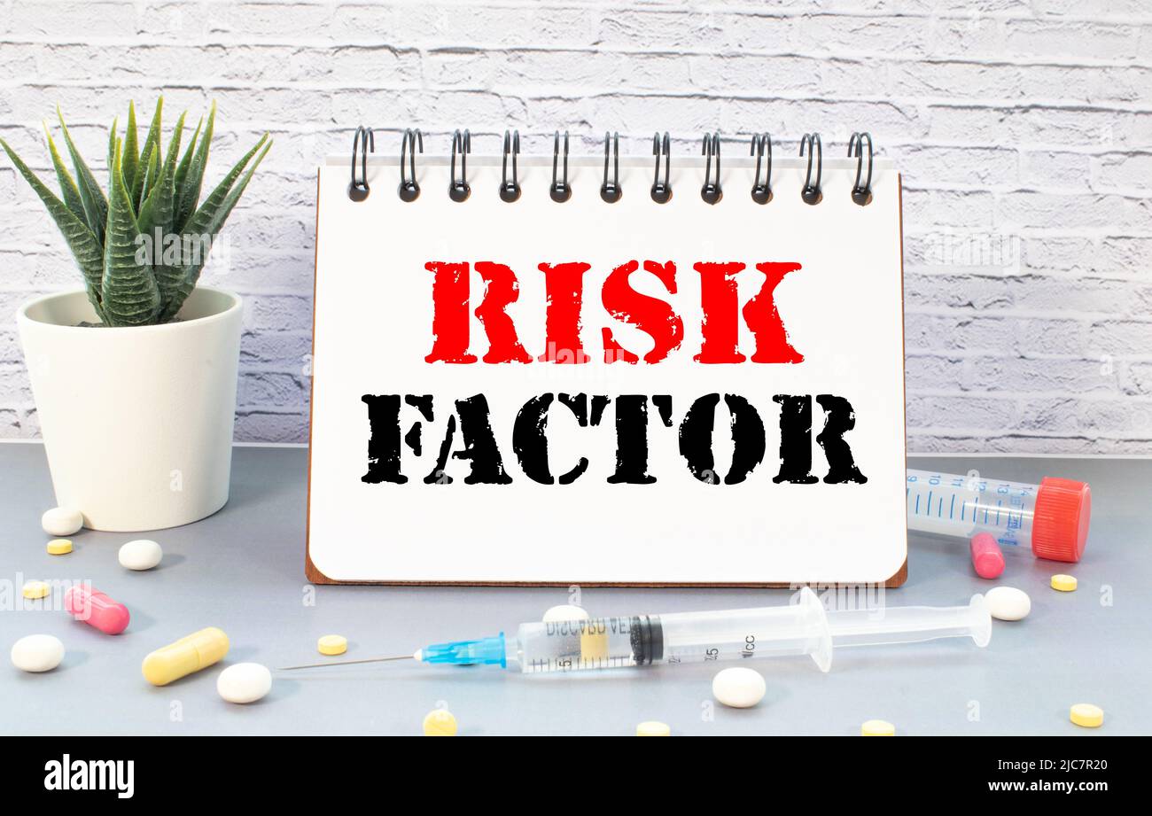 Facteur de risque manuscrit sur note papier avec stéthoscope sur table en bois Banque D'Images