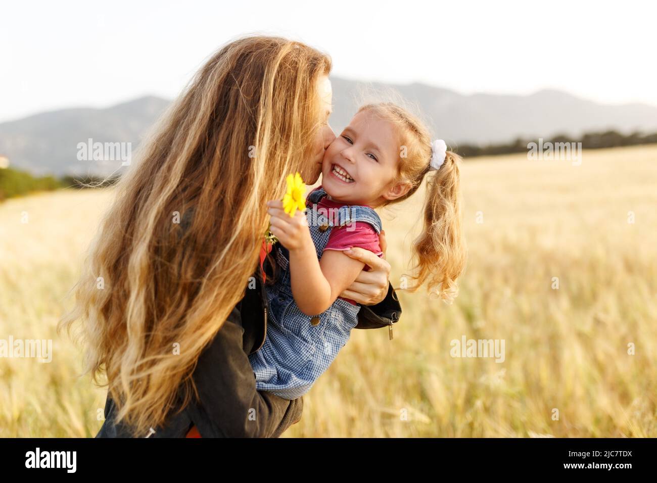 Portrait d'une jeune mère heureuse et de sa belle fille jouant et riant dans un champ de blé . Concept de liberté. Banque D'Images