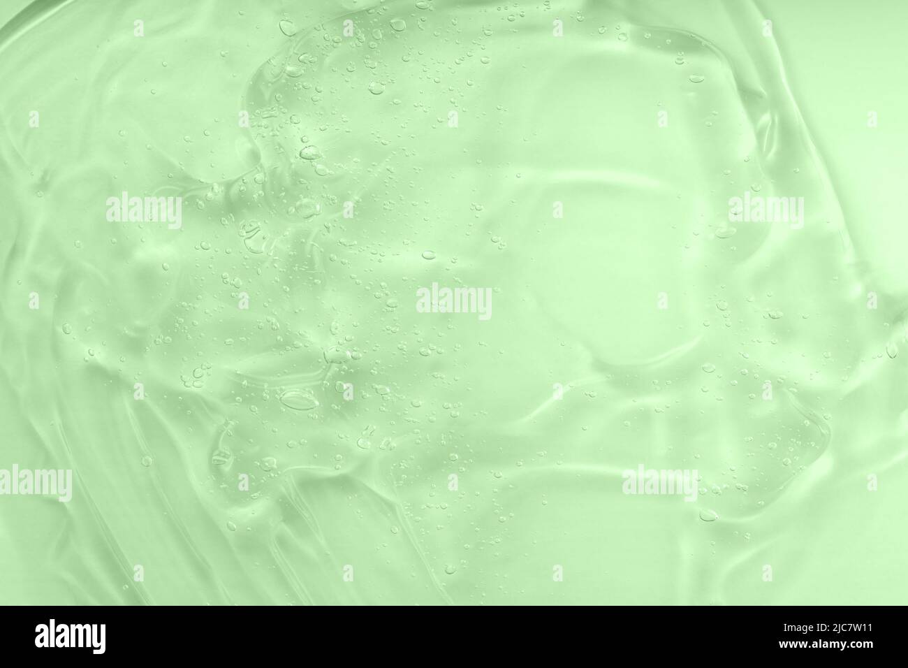 Taches d'huile verte liquide. Le concept de cosmétiques naturels. Échantillon de sérum transparent d'acide hyaluronique. Texture de gel cosmétique Aloe vera avec fond de bulles. Banque D'Images