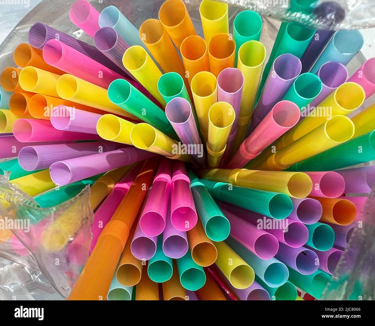 Pailles multicolores dans un sac en plastique, couleur des pailles : jaune, vert, rose, bleu, violet, orange Banque D'Images