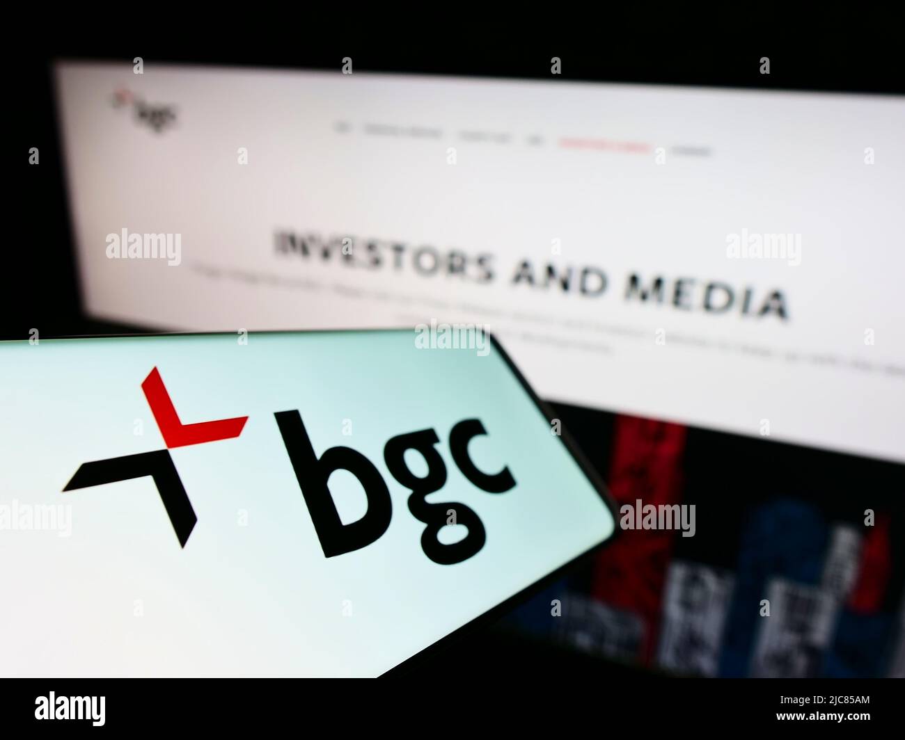 Smartphone avec logo de la société de services financiers américaine BGC Partners Inc. Sur écran devant le site Web. Mise au point au centre-gauche de l'écran du téléphone. Banque D'Images