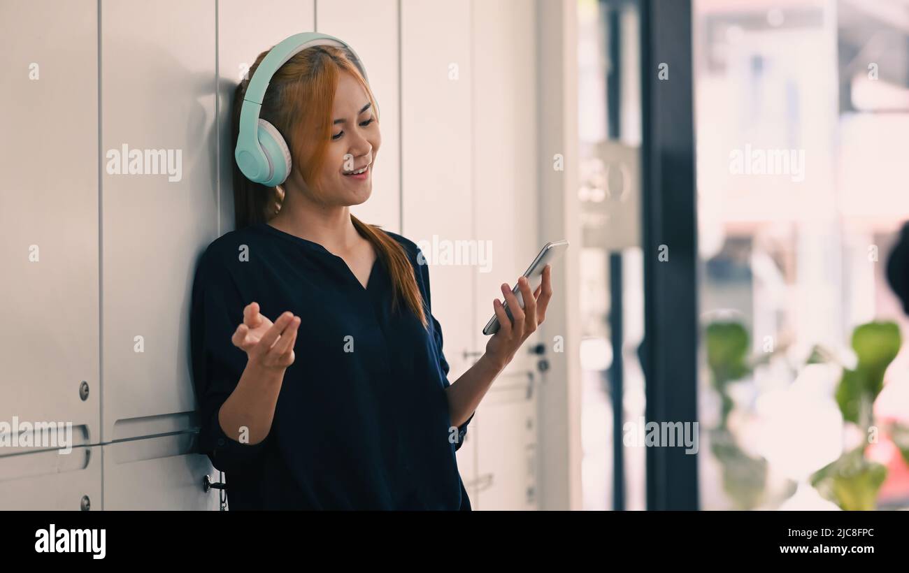 Une jeune femme pleine de joie à porter un casque pour écouter votre chanson préférée tout en passant du temps libre à la maison. Ambiance, passe-temps, concept moderne de technologie sans fil Banque D'Images