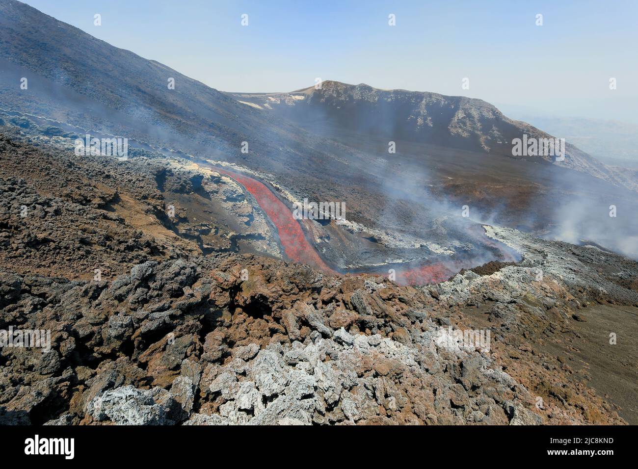 Chute de lave à l'Etna qui coule sur le volcan de la Sicile dans la Valle del Bove avec de la fumée et un canal d'écoulement de lave Banque D'Images