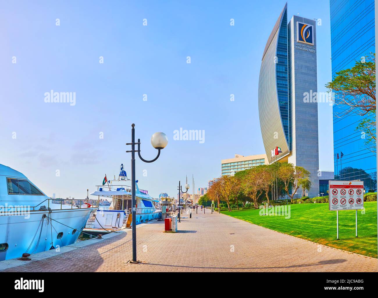 DUBAÏ, Émirats Arabes Unis - 1 MARS 2020 : promenez-vous sur la promenade de la crique dans le quartier de Port Saeed avec vue sur le bâtiment moderne de la Banque nationale et les yachts amarrés, Banque D'Images