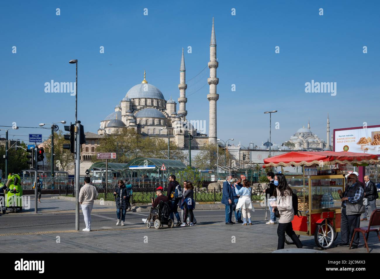 Les piétons wal dans la rue, avec la mosquée Fatih en arrière-plan. Istanbul, Türkiye. Banque D'Images