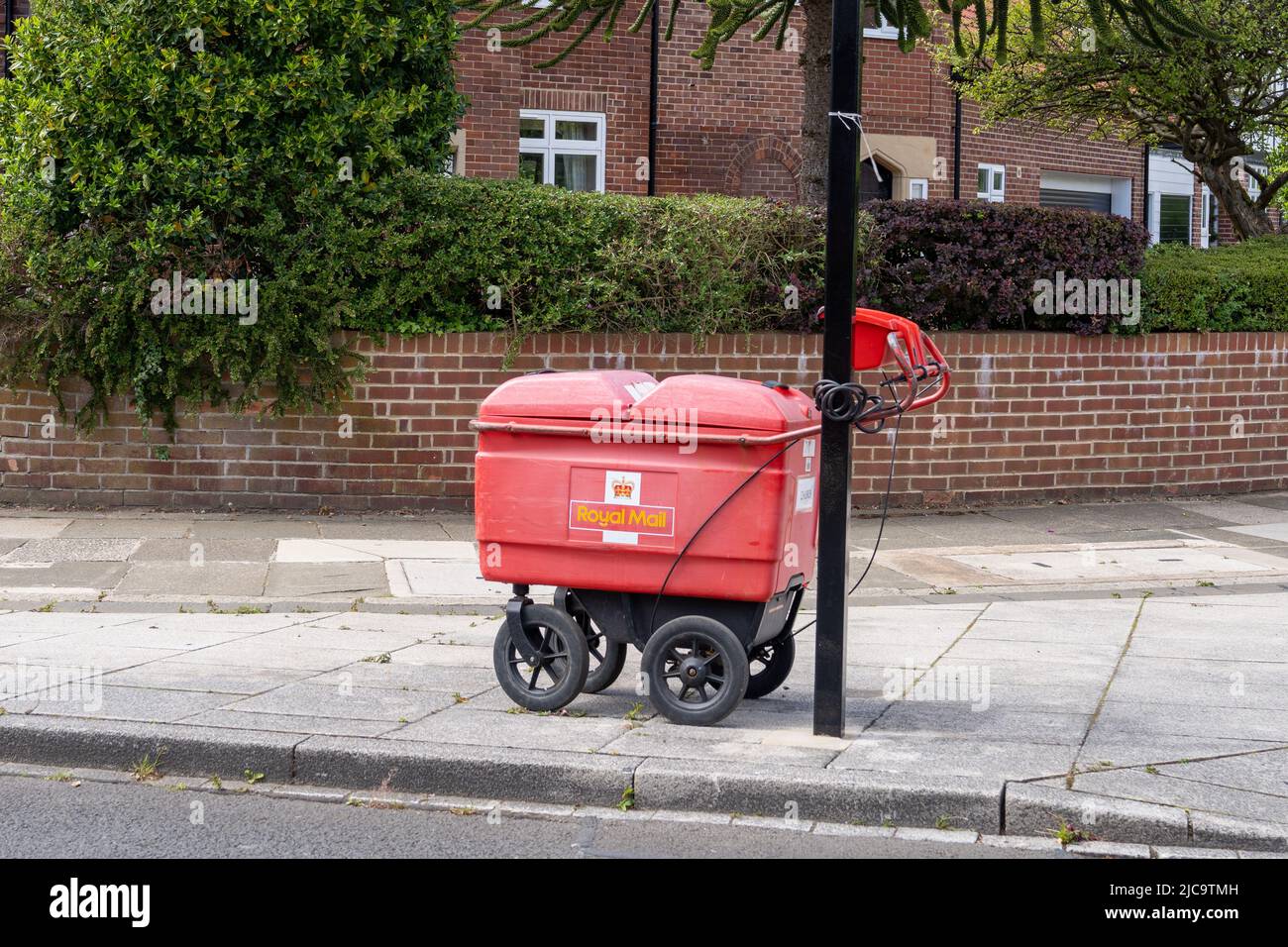 Le chariot du travailleur de la livraison postale Royal Mail est bloqué sur une rampe dans une rue de banlieue de Gosforth, Newcastle upon Tyne, Royaume-Uni. Banque D'Images
