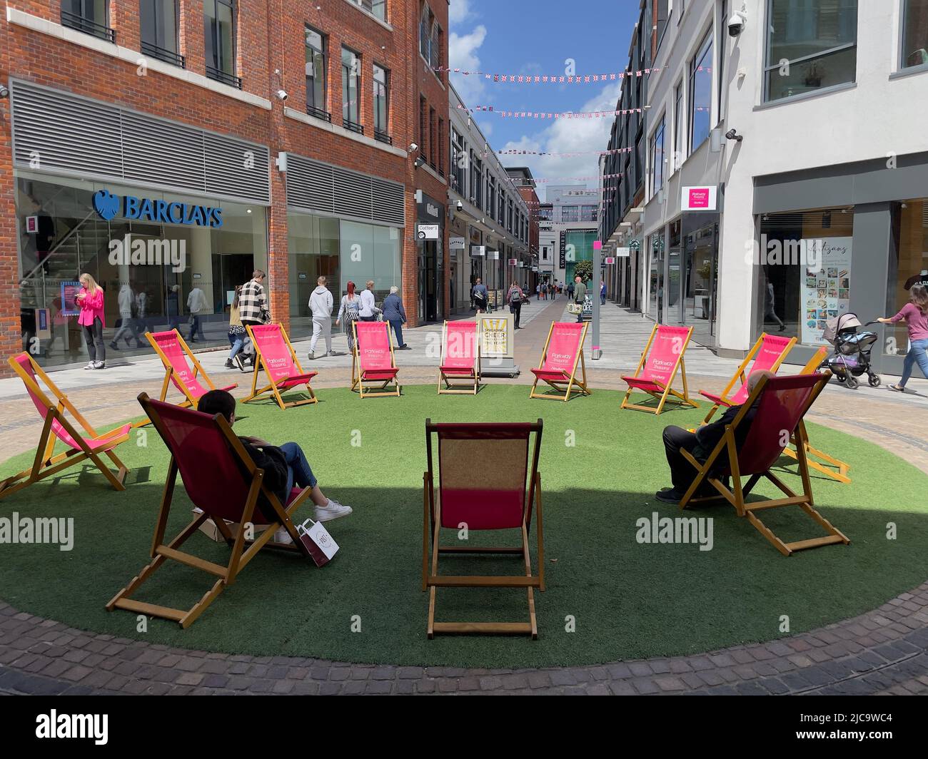 Newbury, berkshire, Angleterre, Royaume-Uni. 2022. Chaises longues sur l'herbe à utiliser par les acheteurs dans le centre-ville. Banque D'Images