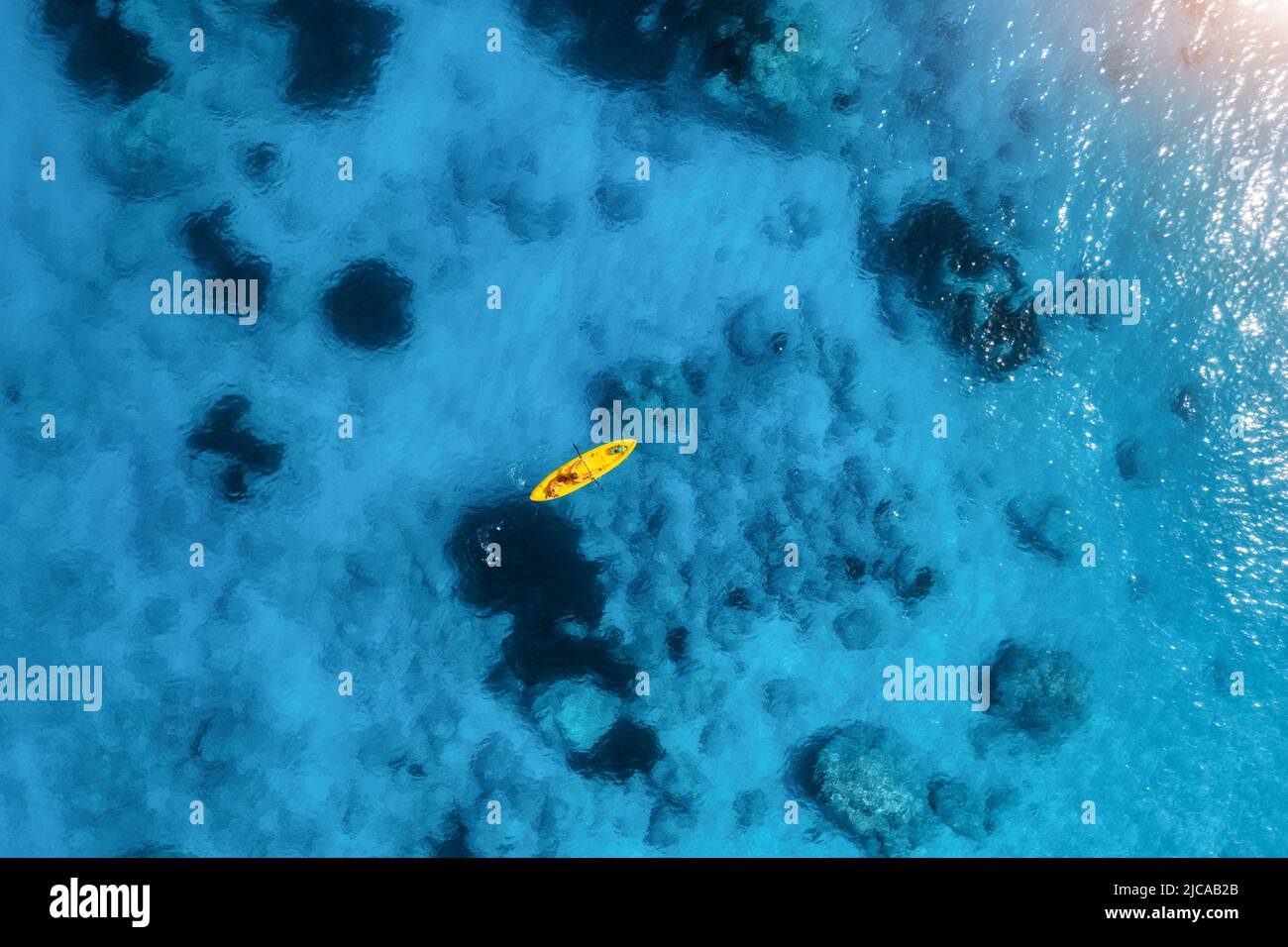 Vue aérienne du kayak jaune en mer bleue au coucher du soleil en été Banque D'Images