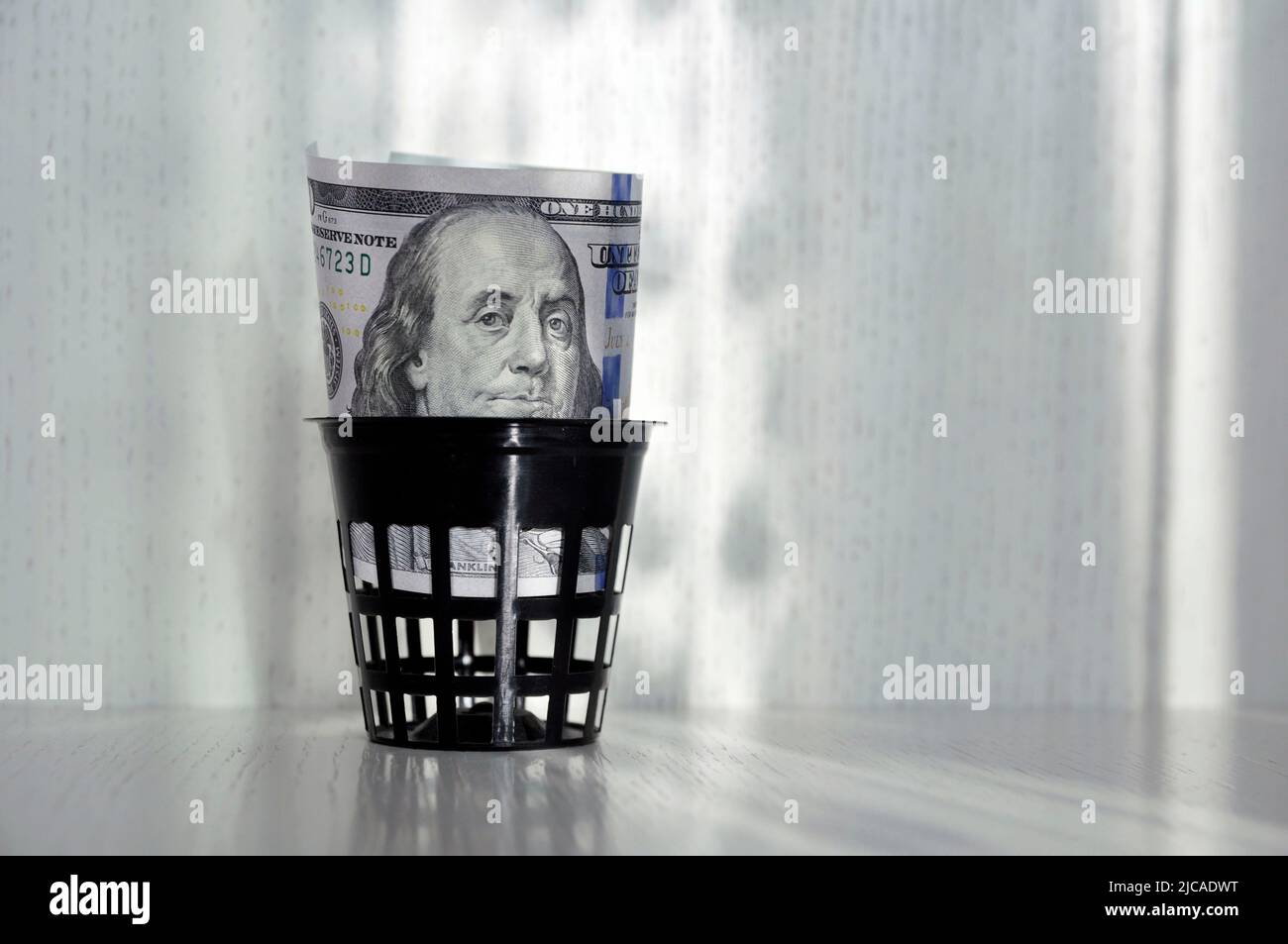 Cent dollars américains dans la poubelle. Le concept de l'effondrement du dollar. Banque D'Images