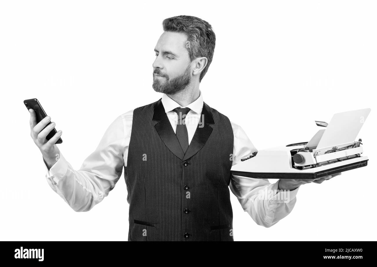 beau homme tient une machine à écrire rétro et un smartphone moderne, la technologie Banque D'Images