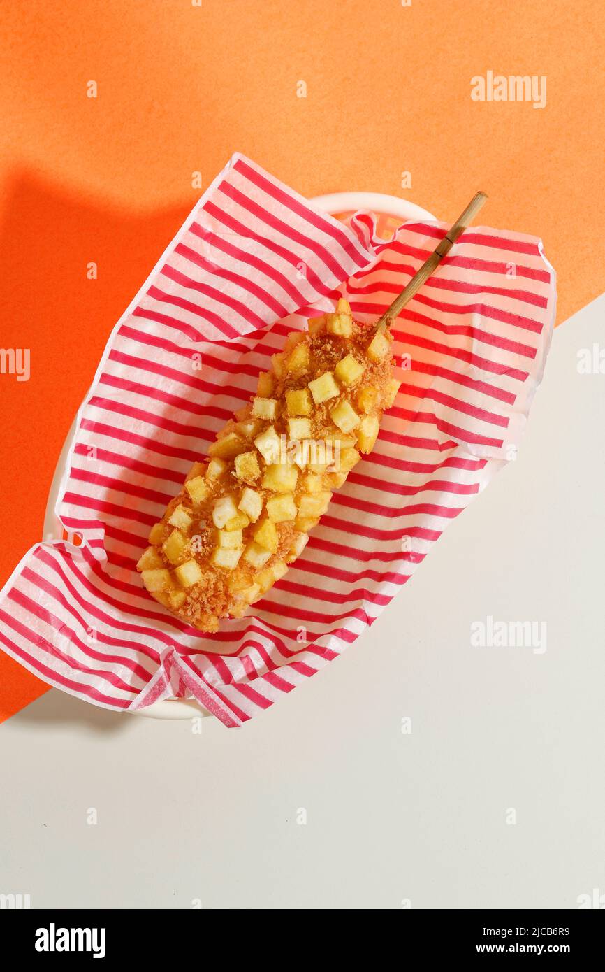 Top View délicieux croquant style coréen Chiffy Potato Corn Dogs avec pâte et pommes de terre frites. Isolé sur fond crème avec espace de copie pour le texte Banque D'Images