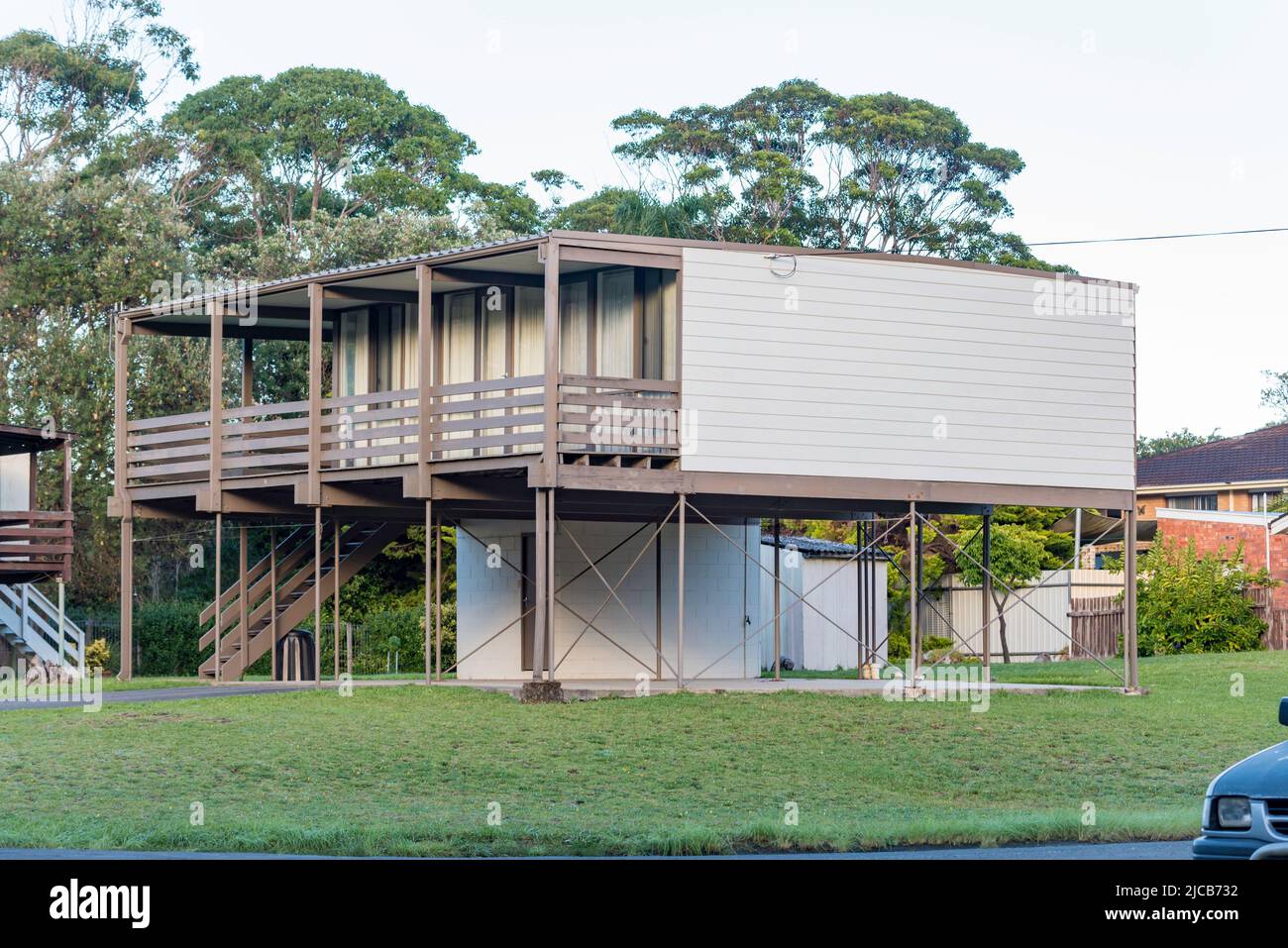 Basé sur le modèle Lend Lease Beachcomber de 1961, cette maison d'après-guerre à Narrawallee, en Nouvelle-Galles du Sud, l'Australie a sa surface habitable au niveau supérieur Banque D'Images