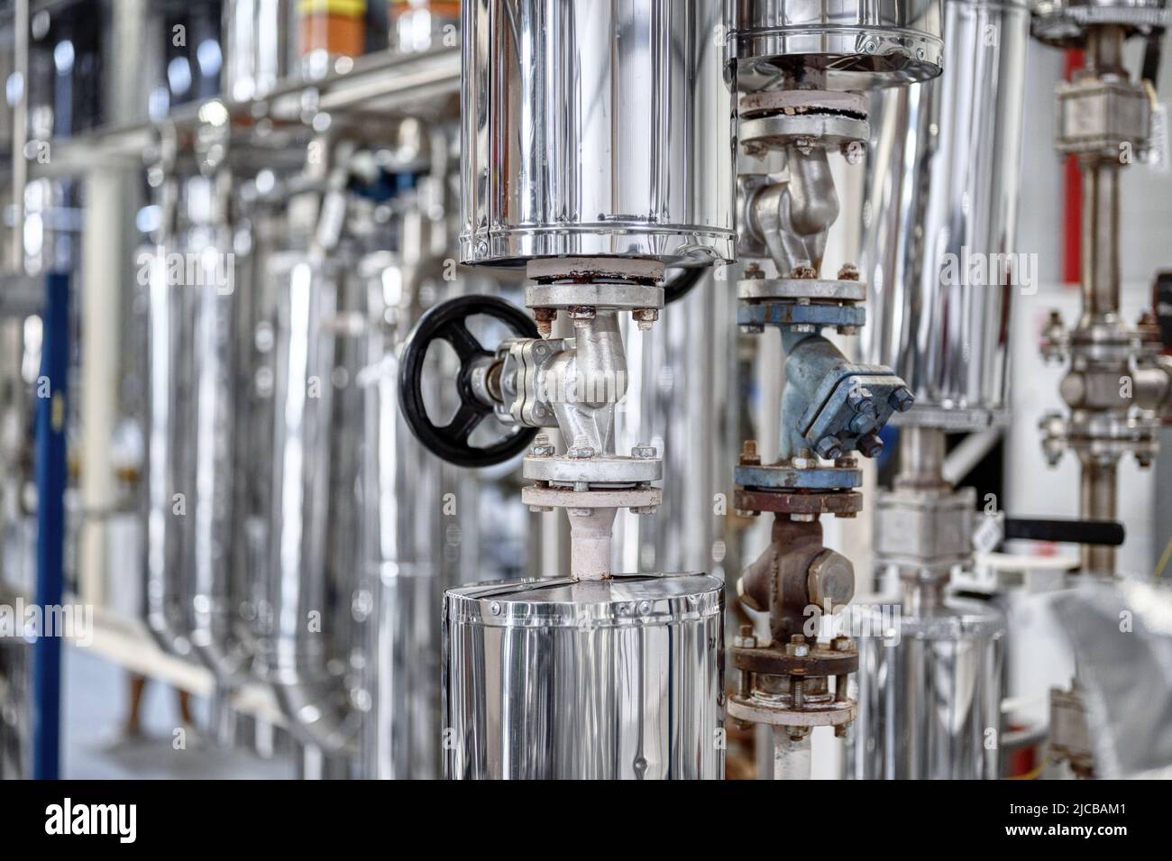 Grand tube avec petite vanne noire à l'usine de production Banque D'Images