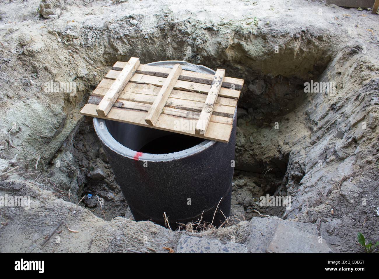 Un entrepreneur en excavation installe une colonne montante sur une voûte de trou d'homme sur un réseau d'égout sanitaire dans le cadre d'un nouveau développement commercial Banque D'Images