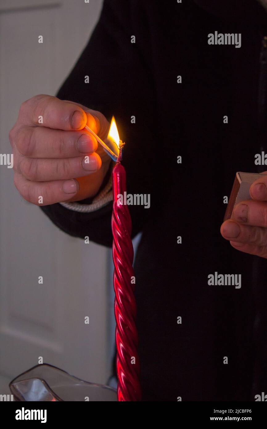 Une fille allume une bougie sur une couronne de Noël Banque D'Images