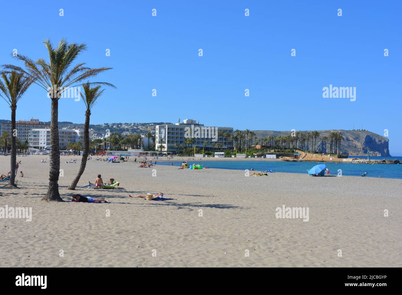 Touristes sur la plage Arenal avec Parador et Cabo San Antonio derrière, Javea, Alicante, Espagne Banque D'Images
