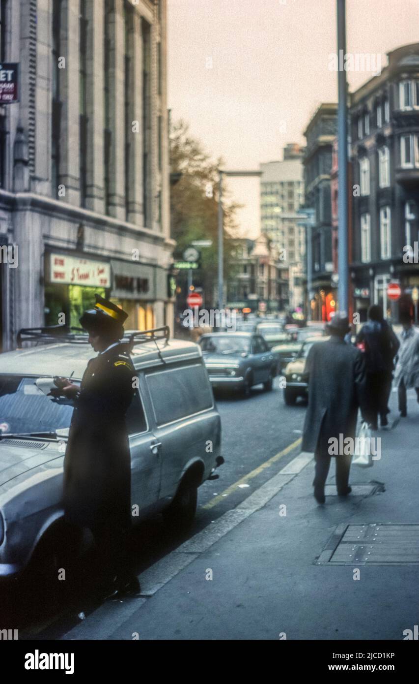 1970s image d'archive d'un garde-trafic écrivant un billet à Wardour Street, Soho, Londres. Banque D'Images