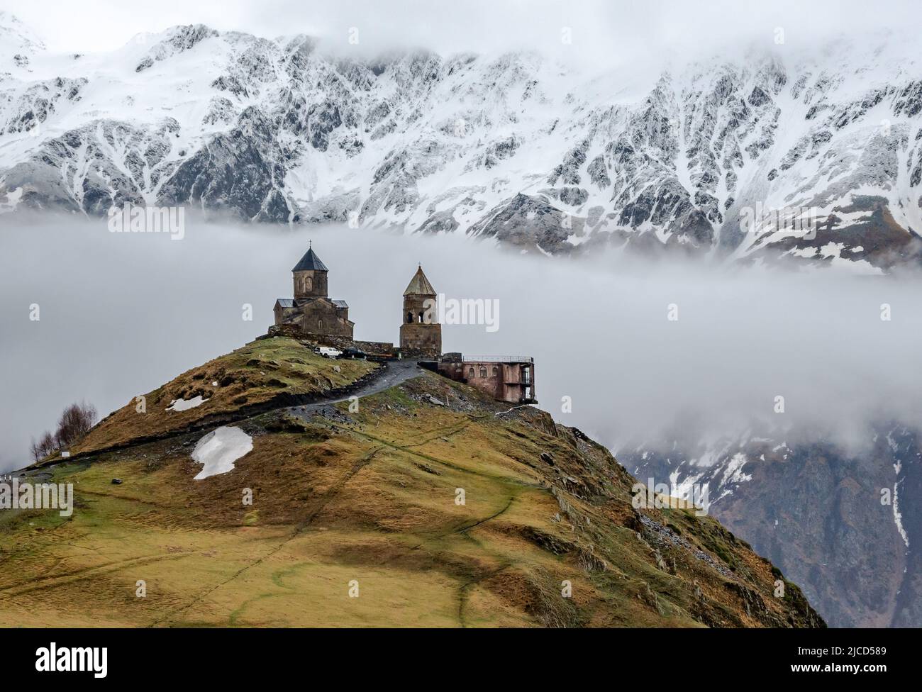 L'église de la Trinité de Gergeti se trouve en face des montagnes du Grand Caucase. Stepantsminda, République de Géorgie. Banque D'Images