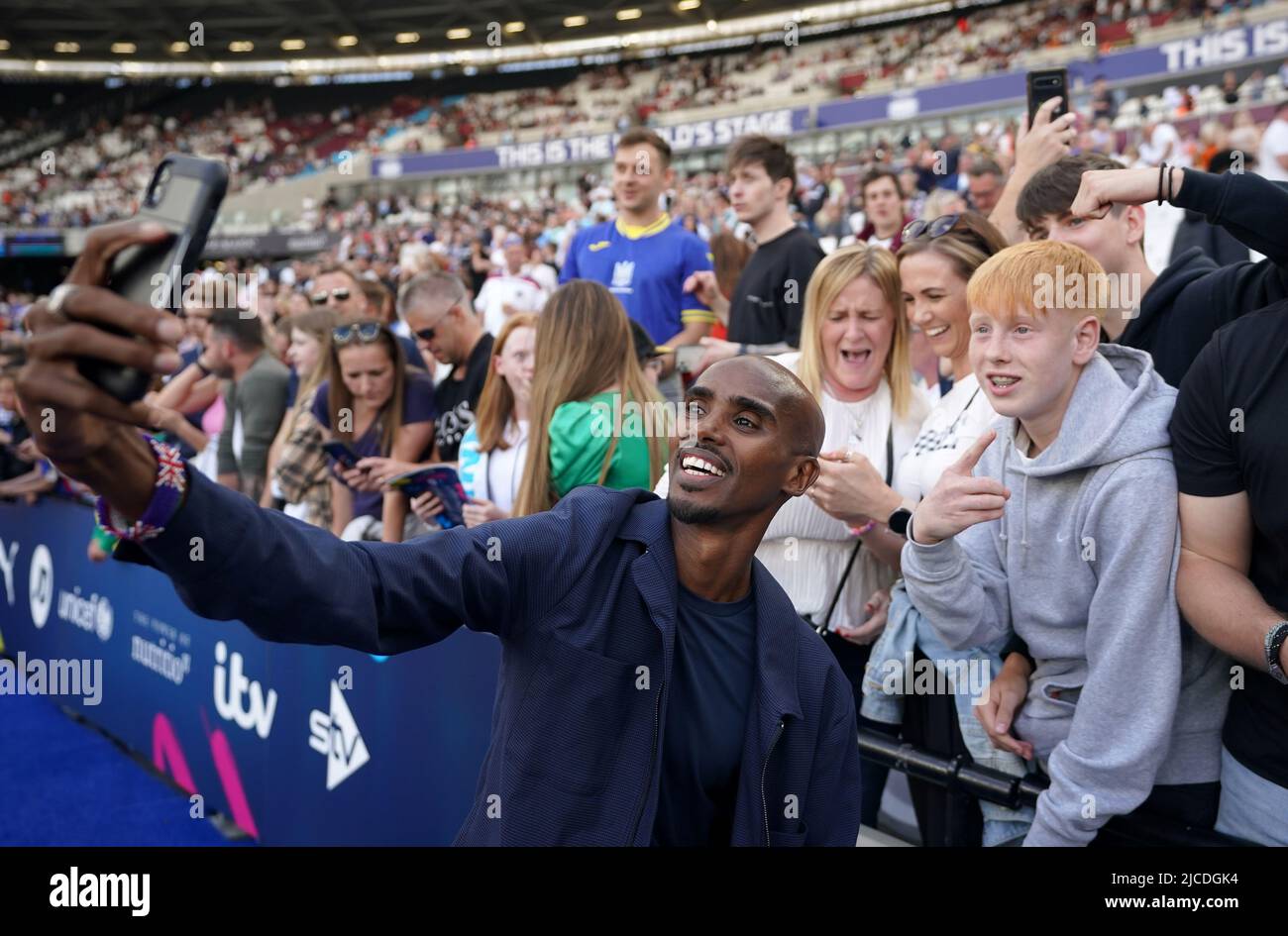 Sir Mo Farah pose un selfie avec la foule avant le match de l'aide au football pour l'UNICEF au stade de Londres, à Londres. Date de la photo: Dimanche 12 juin 2022. Banque D'Images
